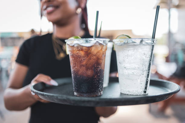 waitress holding drinks tray with soda and sparkling water