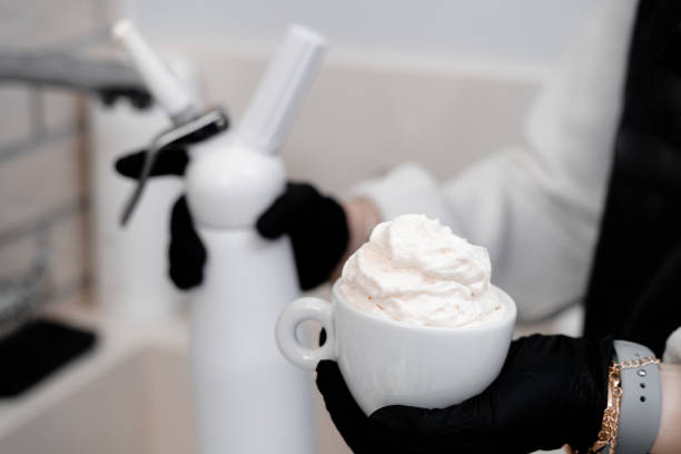 Cream on a cup of coffee in the hands of the barista