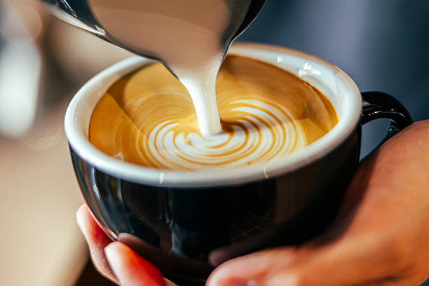 Barista man is preparing latte at coffee shop.